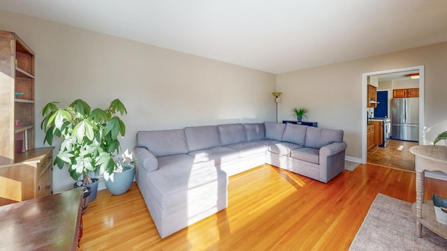 living area featuring light wood-style flooring and baseboards