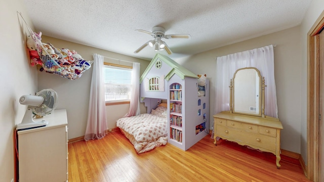 bedroom featuring ceiling fan, a textured ceiling, and wood finished floors