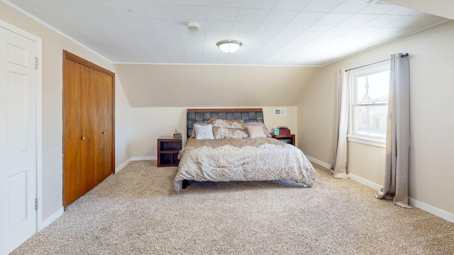 carpeted bedroom with vaulted ceiling, a closet, visible vents, and baseboards