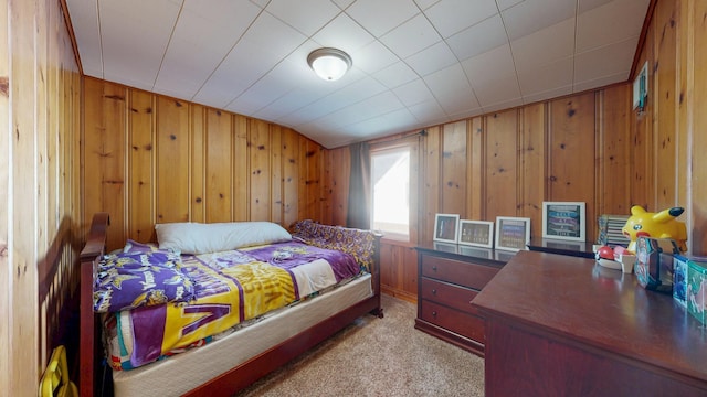 carpeted bedroom featuring wood walls