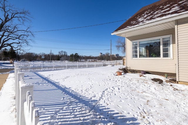 yard covered in snow featuring fence