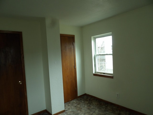 unfurnished bedroom with a closet, carpet, and baseboards