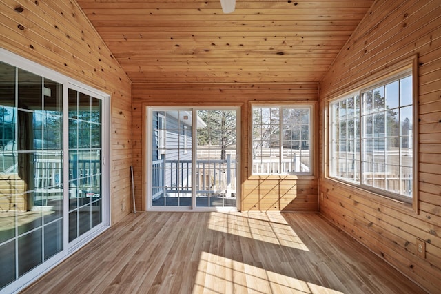 unfurnished sunroom featuring vaulted ceiling, plenty of natural light, and wood ceiling