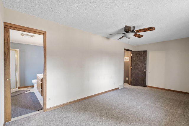 spare room with visible vents, a ceiling fan, a textured ceiling, carpet flooring, and baseboards