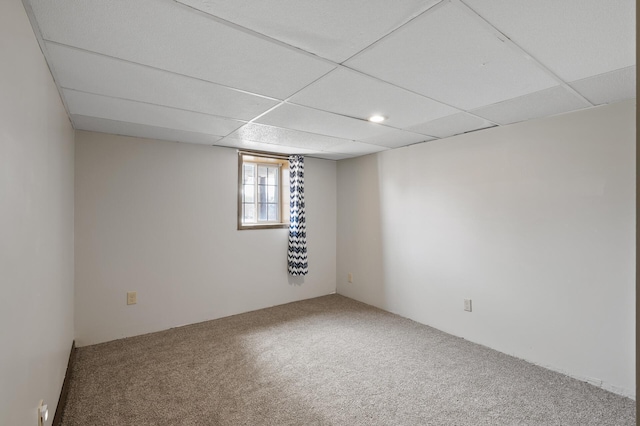 carpeted spare room with a paneled ceiling