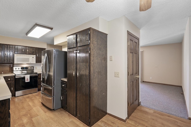 kitchen featuring light countertops, dark brown cabinets, appliances with stainless steel finishes, and light wood finished floors