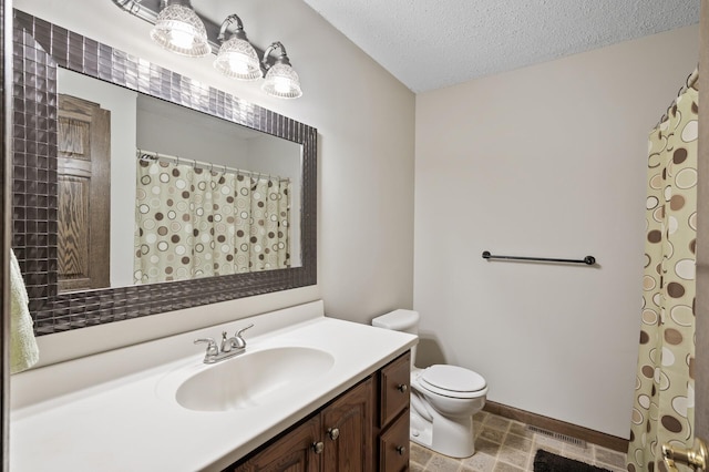 bathroom featuring toilet, a textured ceiling, vanity, and baseboards