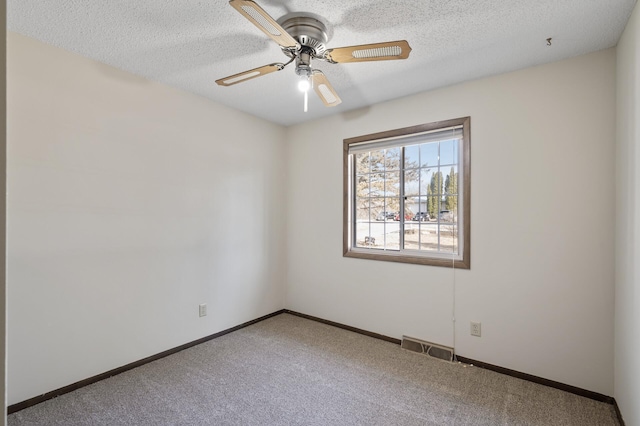 carpeted empty room featuring visible vents, a textured ceiling, baseboards, and a ceiling fan