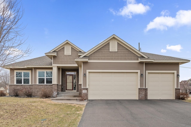 view of front of house featuring an attached garage, roof with shingles, driveway, and brick siding