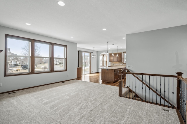 living area featuring recessed lighting, visible vents, baseboards, and dark carpet