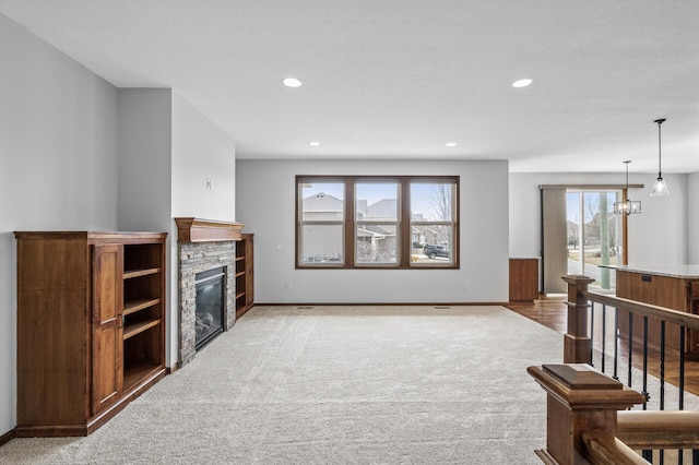 living area featuring a stone fireplace, recessed lighting, carpet flooring, and baseboards