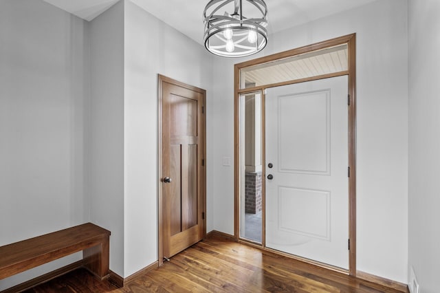 entrance foyer featuring baseboards, a chandelier, and wood finished floors