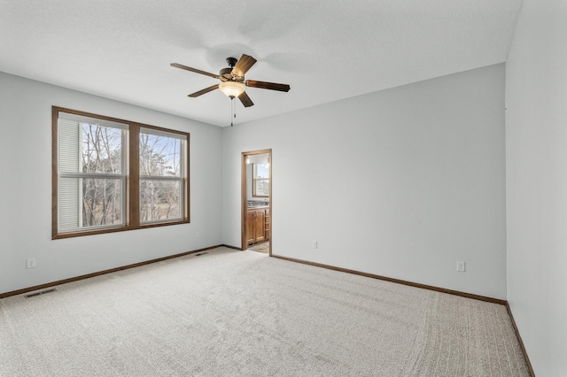 unfurnished room featuring light carpet, ceiling fan, baseboards, and visible vents