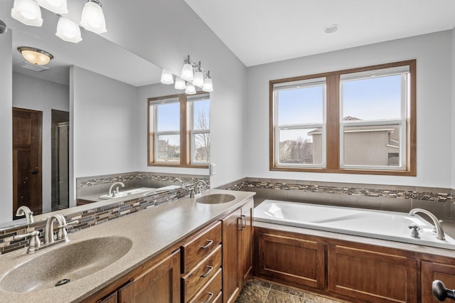 bathroom featuring a sink, a wealth of natural light, and a garden tub