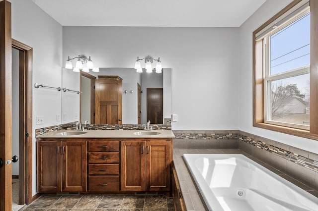full bathroom featuring a sink, a whirlpool tub, and double vanity