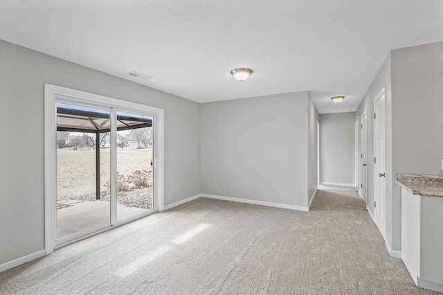 empty room with light carpet, baseboards, and visible vents