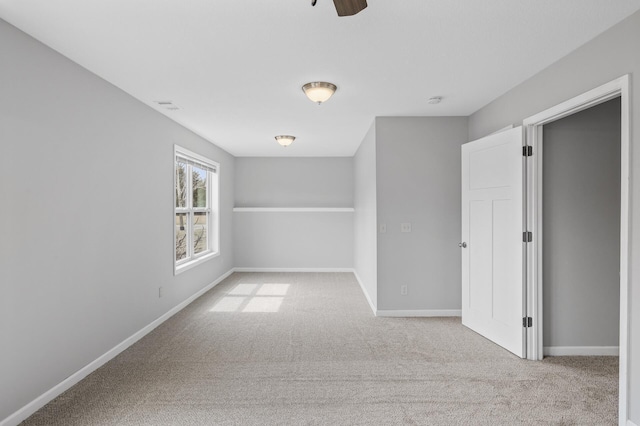 carpeted spare room featuring baseboards