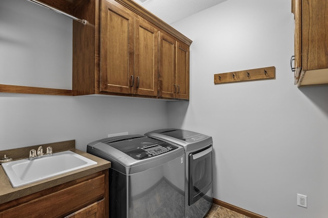 washroom with a sink, cabinet space, and washer and dryer