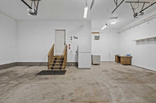 garage with a garage door opener and freestanding refrigerator