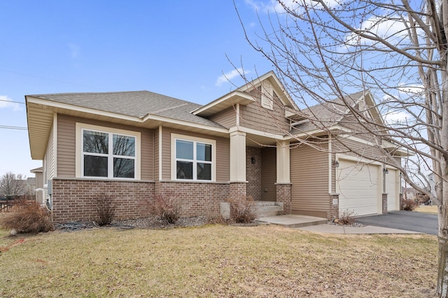 craftsman-style house featuring a garage, aphalt driveway, brick siding, and a front lawn