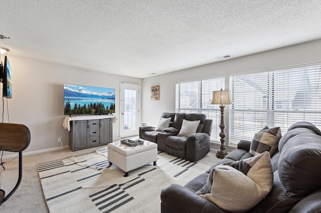 living area with visible vents, baseboards, light colored carpet, and a textured ceiling