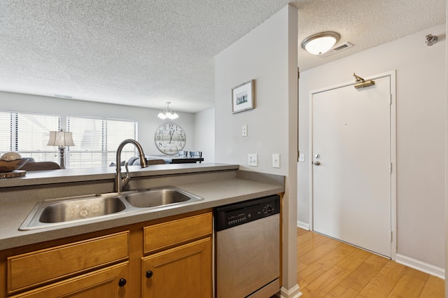 kitchen with light wood-type flooring, visible vents, a sink, stainless steel dishwasher, and a chandelier