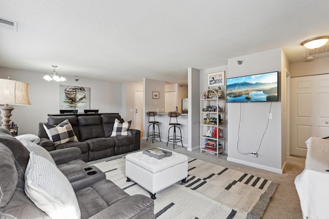 living room with baseboards, visible vents, a textured ceiling, light carpet, and a notable chandelier