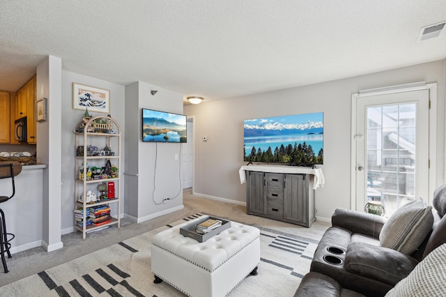 living area featuring light carpet, visible vents, a textured ceiling, and baseboards