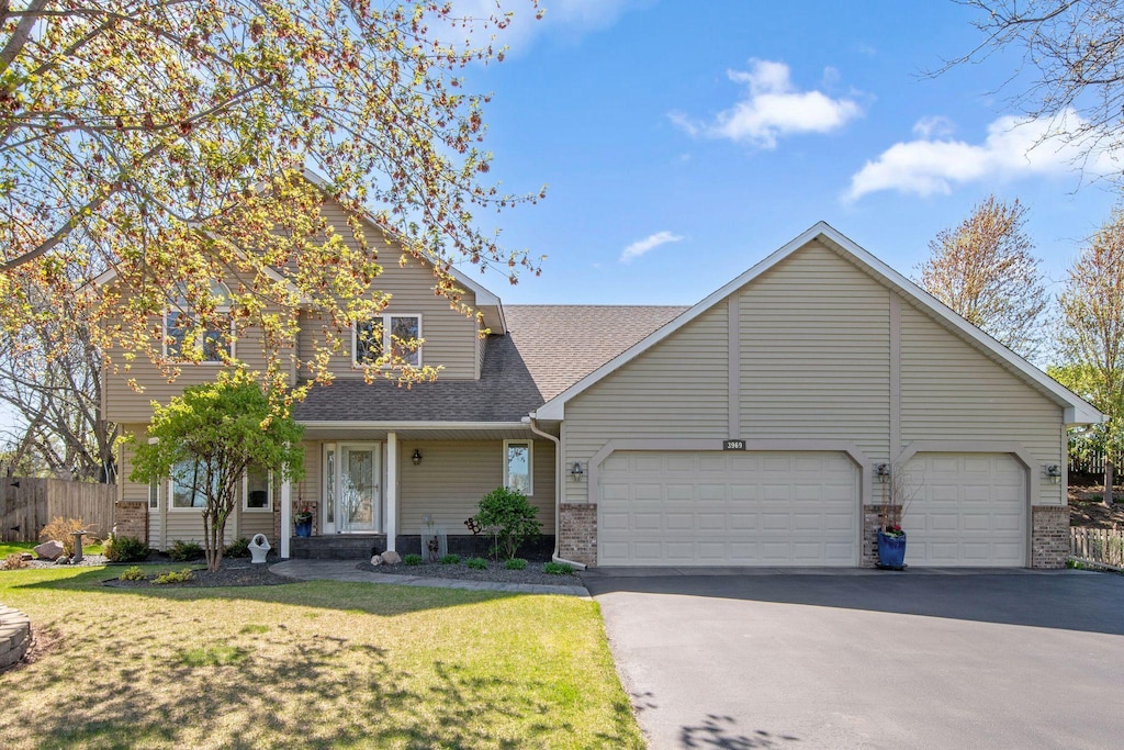 3969 Northview Ter, Eagan, MN 55123 - traditional home featuring driveway, brick siding, an attached garage, roof with shingles, and a front lawn