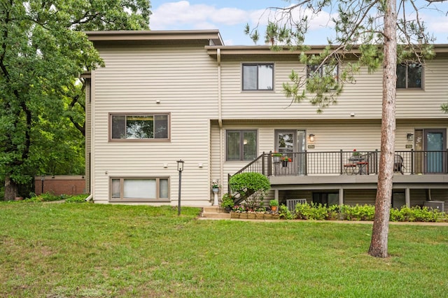 back of house featuring a lawn, a deck, and stairs