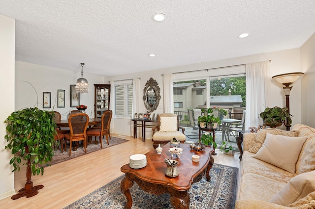 living area featuring a textured ceiling, wood finished floors, and recessed lighting