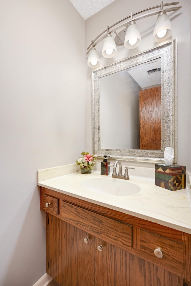 bathroom with visible vents, vanity, and a textured ceiling