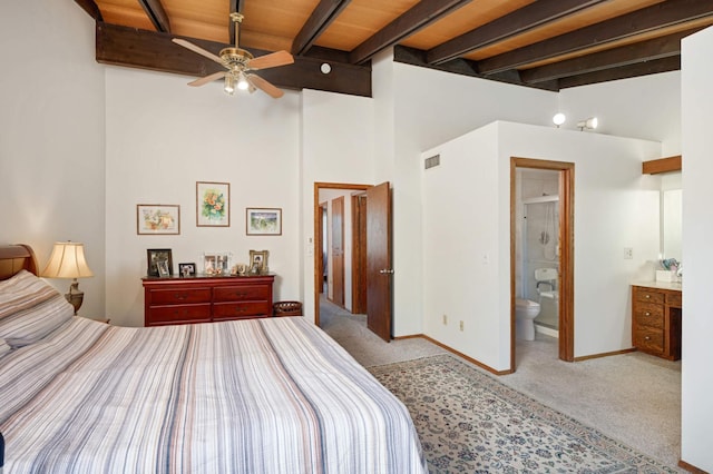 carpeted bedroom featuring visible vents, baseboards, beamed ceiling, and ensuite bathroom