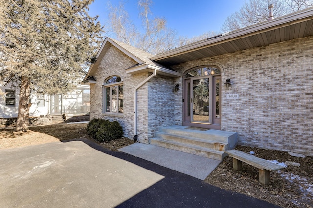 entrance to property featuring brick siding