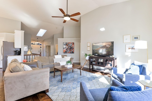 living area with ceiling fan, a skylight, and high vaulted ceiling