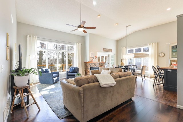 living room featuring a glass covered fireplace, dark wood finished floors, recessed lighting, lofted ceiling, and ceiling fan