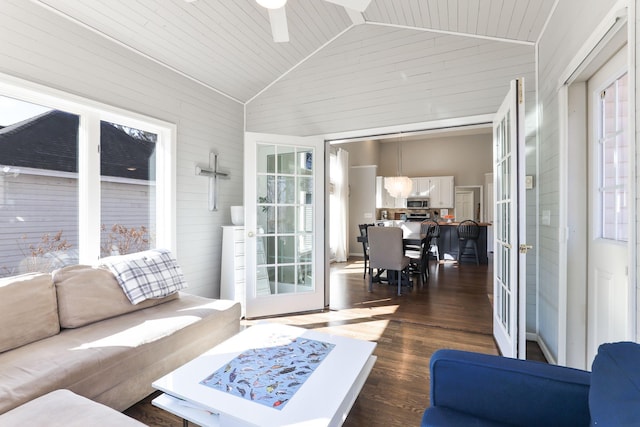 living area featuring dark wood-type flooring, high vaulted ceiling, french doors, wood walls, and ceiling fan