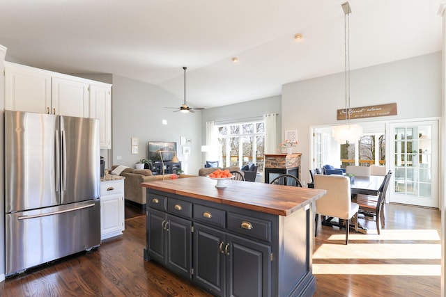 kitchen with freestanding refrigerator, white cabinets, wooden counters, dark wood-style flooring, and vaulted ceiling