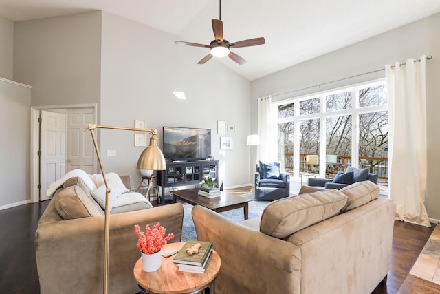 living room with ceiling fan, high vaulted ceiling, baseboards, and dark wood-style flooring