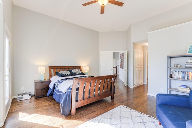 bedroom featuring a ceiling fan, baseboards, and wood finished floors