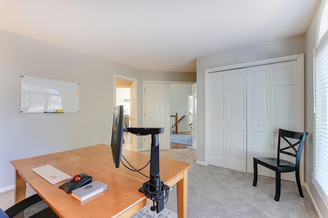 home office featuring baseboards and light colored carpet