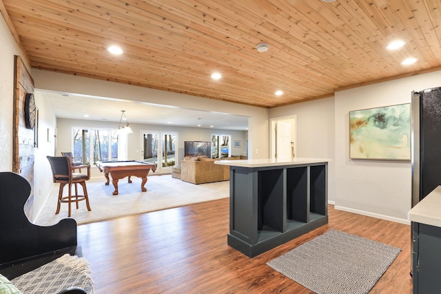 interior space featuring billiards, wood finished floors, freestanding refrigerator, light countertops, and wood ceiling