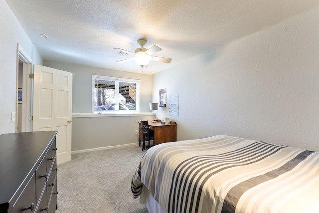 bedroom with baseboards, light colored carpet, ceiling fan, and a textured ceiling