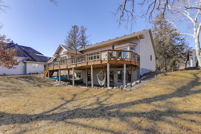 back of house featuring a wooden deck and a yard