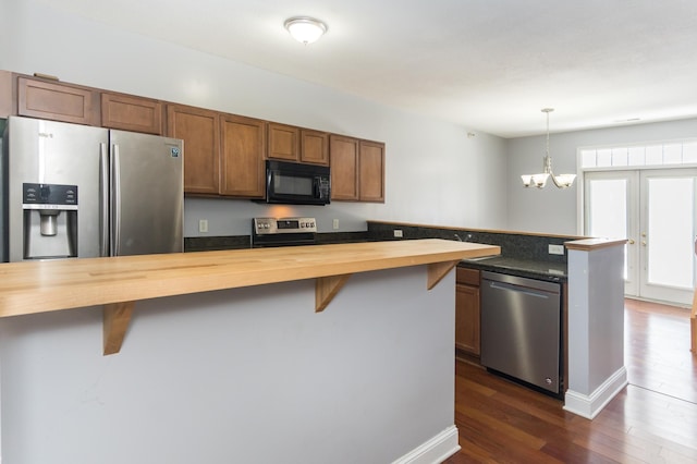 5640 Winnetka Ave N, New Hope, MN 55428 - kitchen featuring an inviting chandelier, a peninsula, appliances with stainless steel finishes, butcher block countertops, and dark wood-style floors