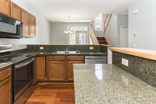 5640 Winnetka Ave N, New Hope, MN 55428 - kitchen featuring dark wood-style flooring, a peninsula, brown cabinetry, stainless steel appliances, and a sink