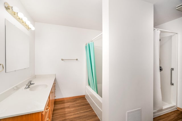 bathroom featuring shower / bath combination with curtain, visible vents, wood finished floors, and vanity