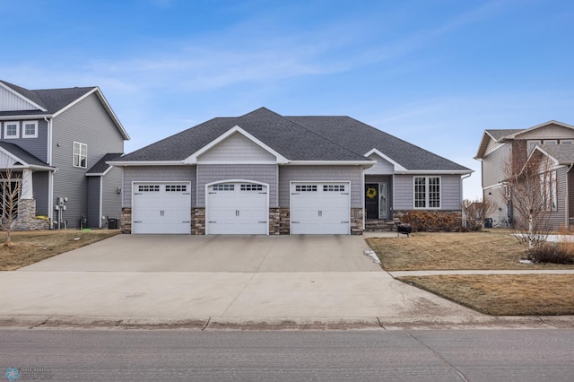 view of front of house with an attached garage, stone siding, driveway, and roof with shingles