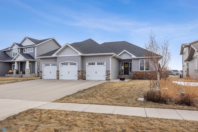 view of front facade featuring a garage, stone siding, roof with shingles, and concrete driveway