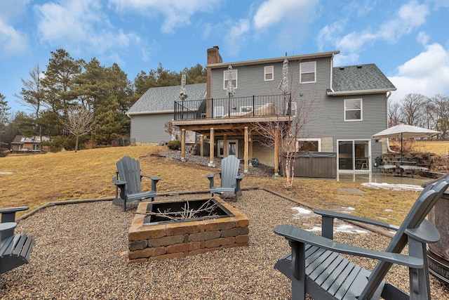 back of property featuring a patio, a fire pit, a wooden deck, a chimney, and a hot tub